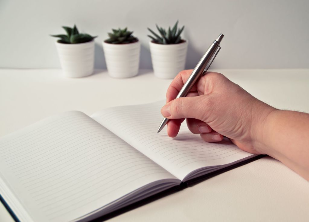 ノートにペンで書き込みながら考える様子